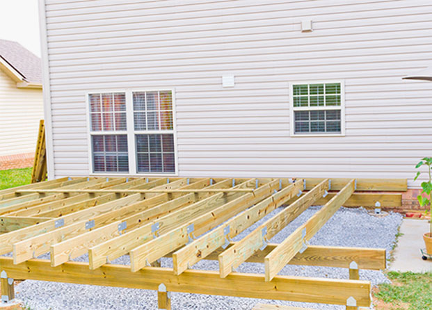 Custom-built deck with wood railing and seating area, designed and installed by Dock Dogs Construction for a New Hampshire lakefront property.