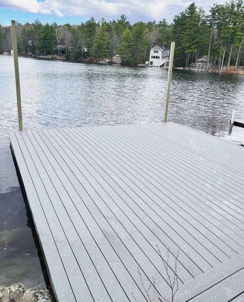 Custom-built dock with composite decking on a scenic New Hampshire lake, designed and installed by Dock Dogs Construction.